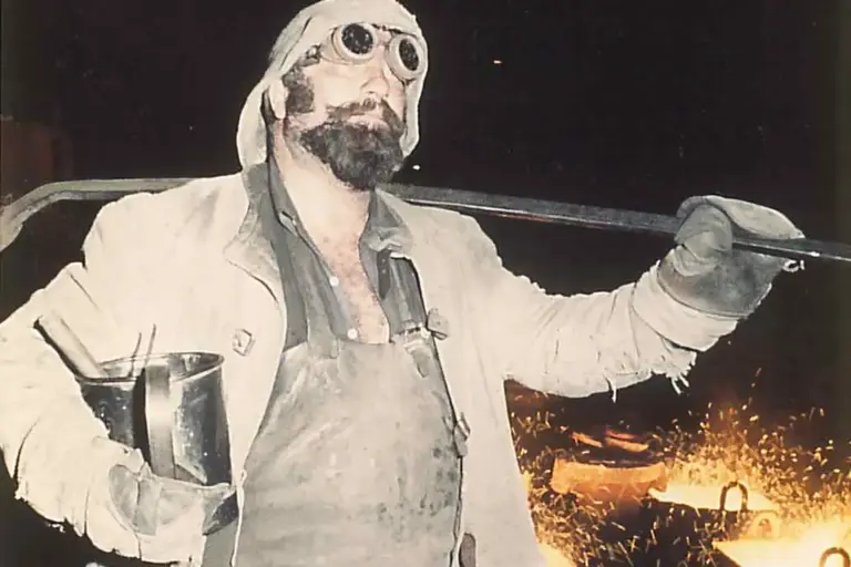 Ein Mann in alter Schutzkleidung in einer Fabrik