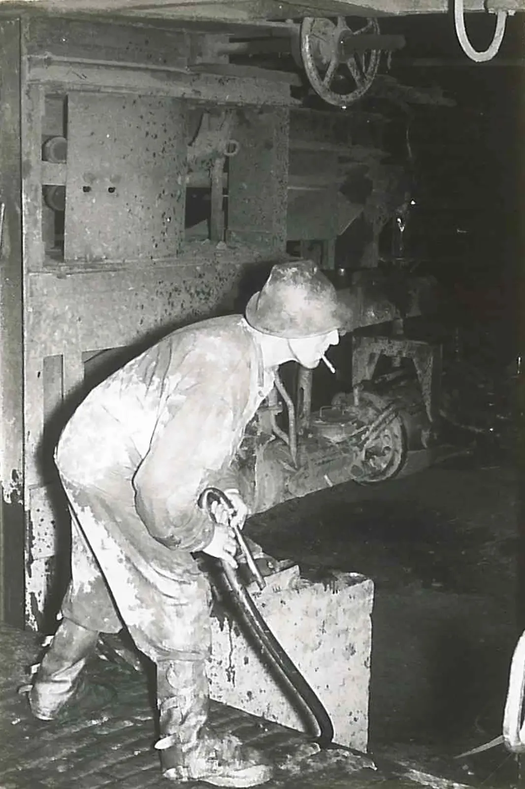 Ein Mann in alter Schutzkleidung in einer Fabrik