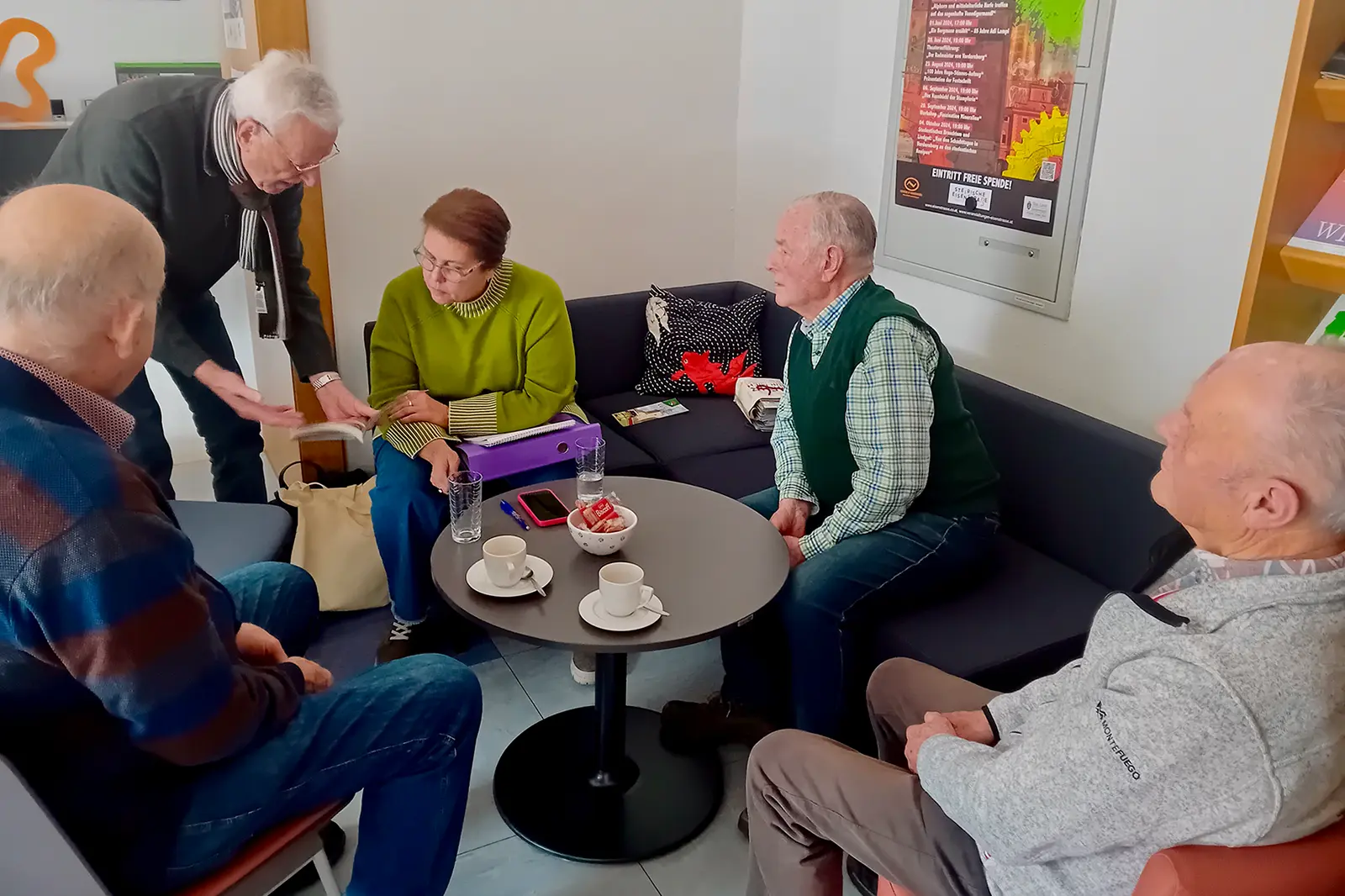 Eine Frau im Gespräch mit vier älteren Männern