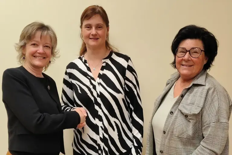 Drei Frauen schütteln einander die Hände