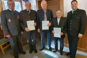 Fünf Männer in Tracht halten drei Urkunden