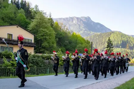Eine Musikkapelle auf einer Straße vor einem Berg