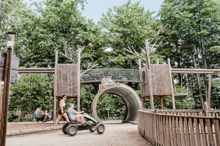 Ein Kind auf einem Tretauto in einem Erlebnispark