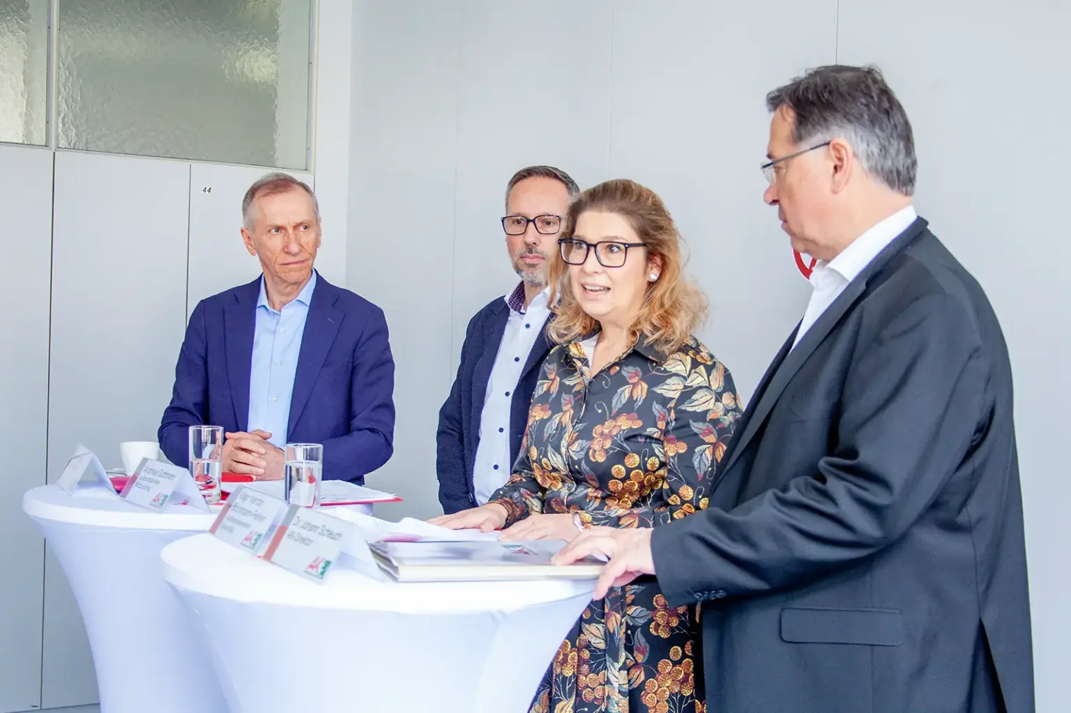 Eine Frau und drei Männer bei einem Pressegespräch