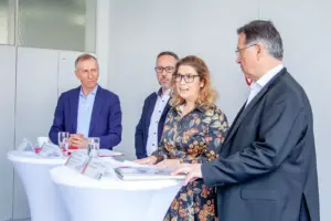 Eine Frau und drei Männer bei einem Pressegespräch