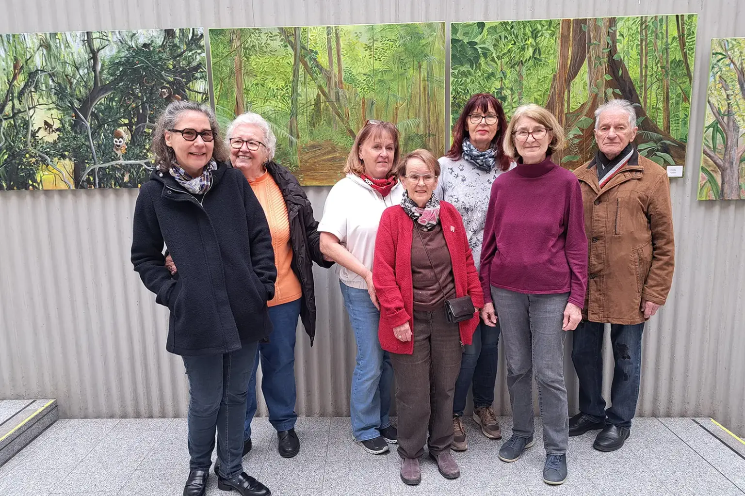 Dschungelkunst im Brucker Rathaushof Ein Mann und sieben Frauen stehen vor einer Wand mit Bildern