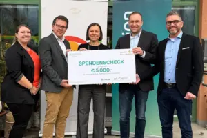 Drei Männer und zwei Frauen mit einem großen Spendenscheck