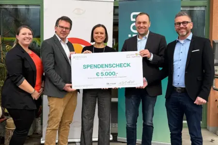 Drei Männer und zwei Frauen mit einem großen Spendenscheck