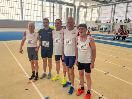 Fünf Männer stehen nebeneinander in einer Leichtathletik-Halle.