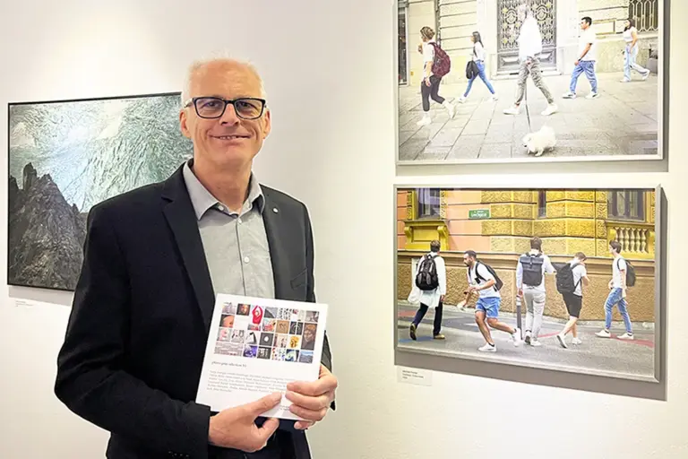 Brucker Fotokunst zu Gast in Marburg Ein Mann mit Brille vor einer Wand mit Bildern
