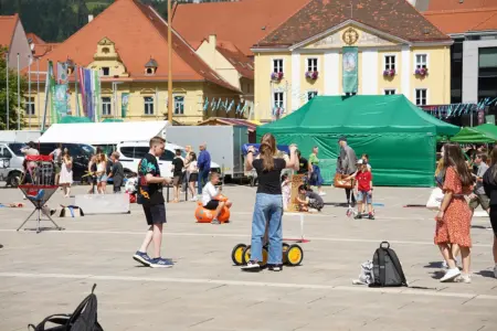 Kinder mit verschiedenen Spielgeräten auf einem großen Platz