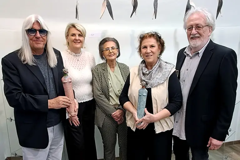 Zwei Männer und drei Frauen halten Keramikstatutetten