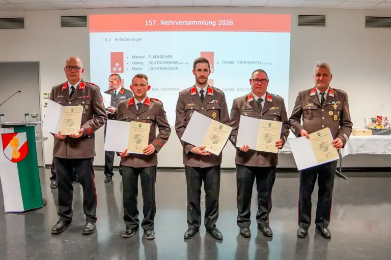 Fünf Männer in Uniform präsentieren Urkunden