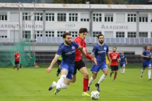 Zwei Fußballer kämpfen um den Ball.