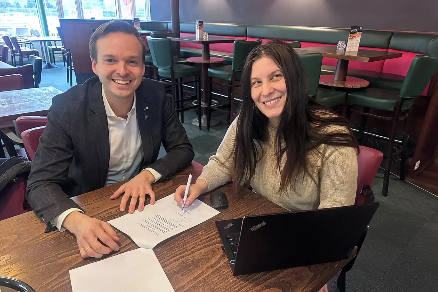 Ein Mann und eine Frau sitzen mit Papieren an einem Tisch