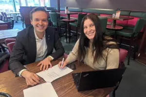 Ein Mann und eine Frau sitzen mit Papieren an einem Tisch