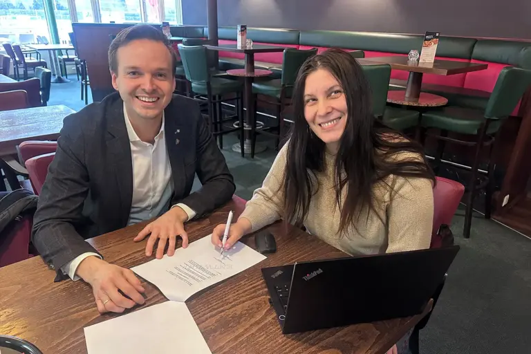 Ein Mann und eine Frau sitzen mit Papieren an einem Tisch