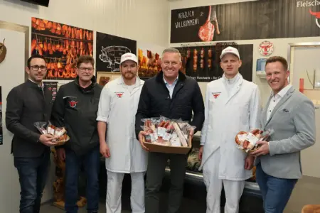 Sechs Männer mit Wurstwaren in einer Fleischerei