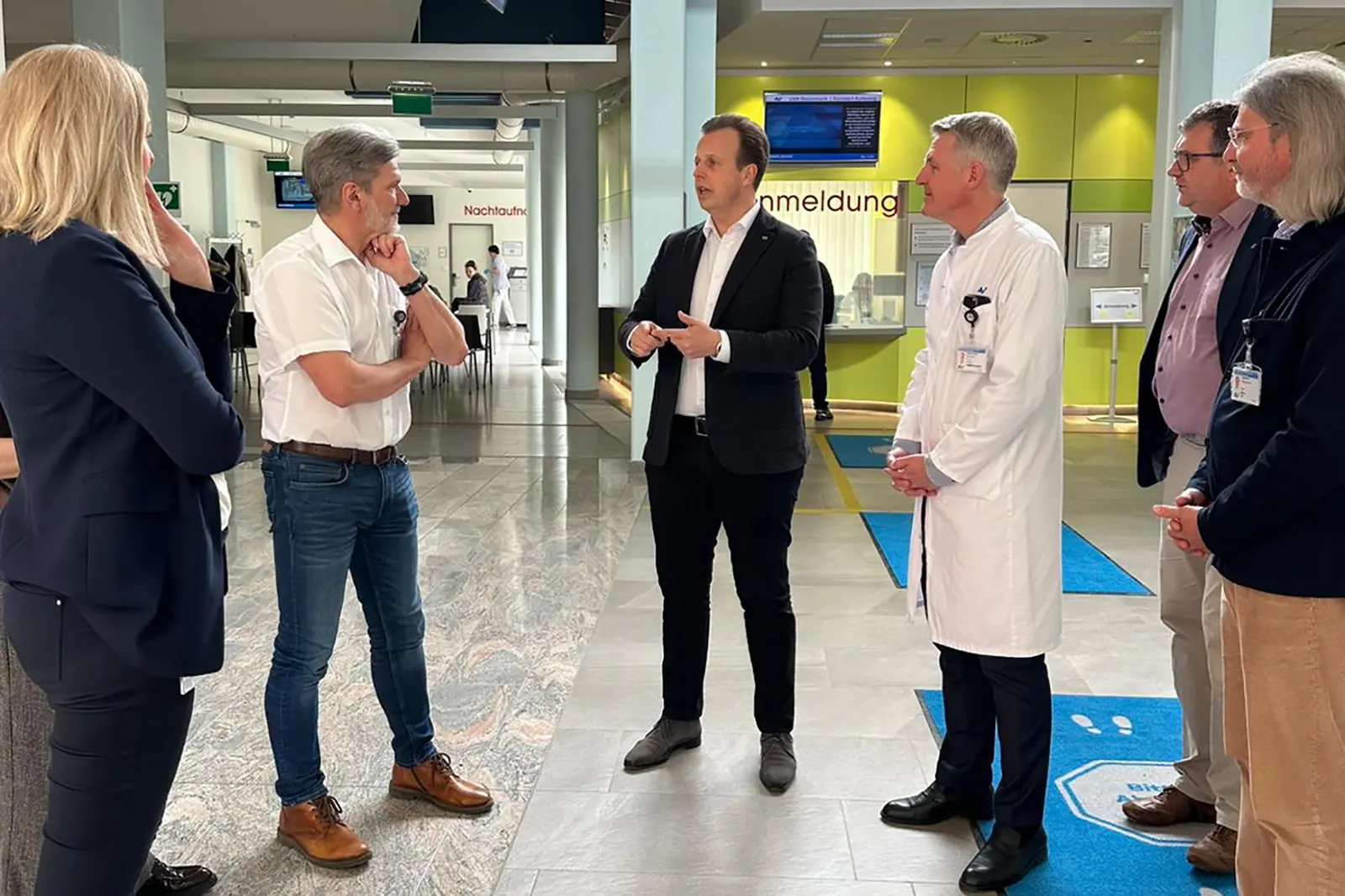 Sechs Personen unterhalten sich in einem großen Raum