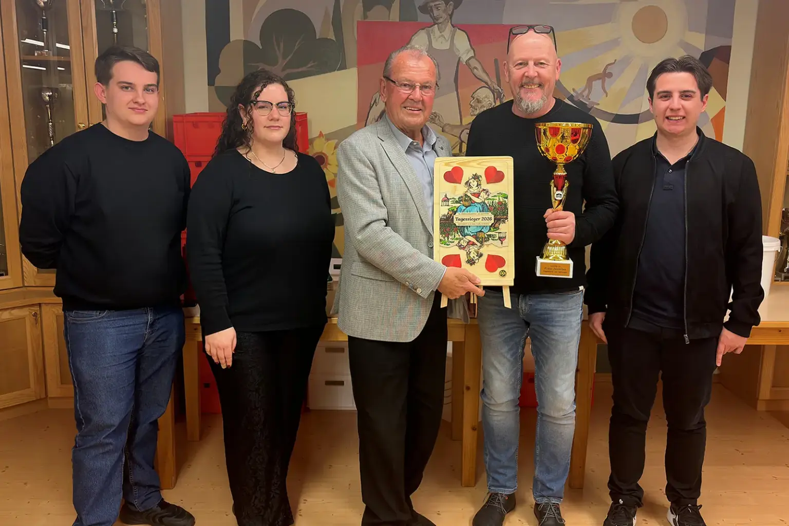 Siegfried Hochfellner ist Kammerner Schnapserkönig Vier Männer und eine Frau mit einem Pokal und einer großen Spielkarte