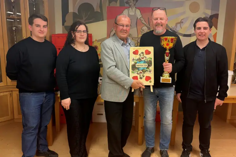 Siegfried Hochfellner ist Kammerner Schnapserkönig Vier Männer und eine Frau mit einem Pokal und einer großen Spielkarte