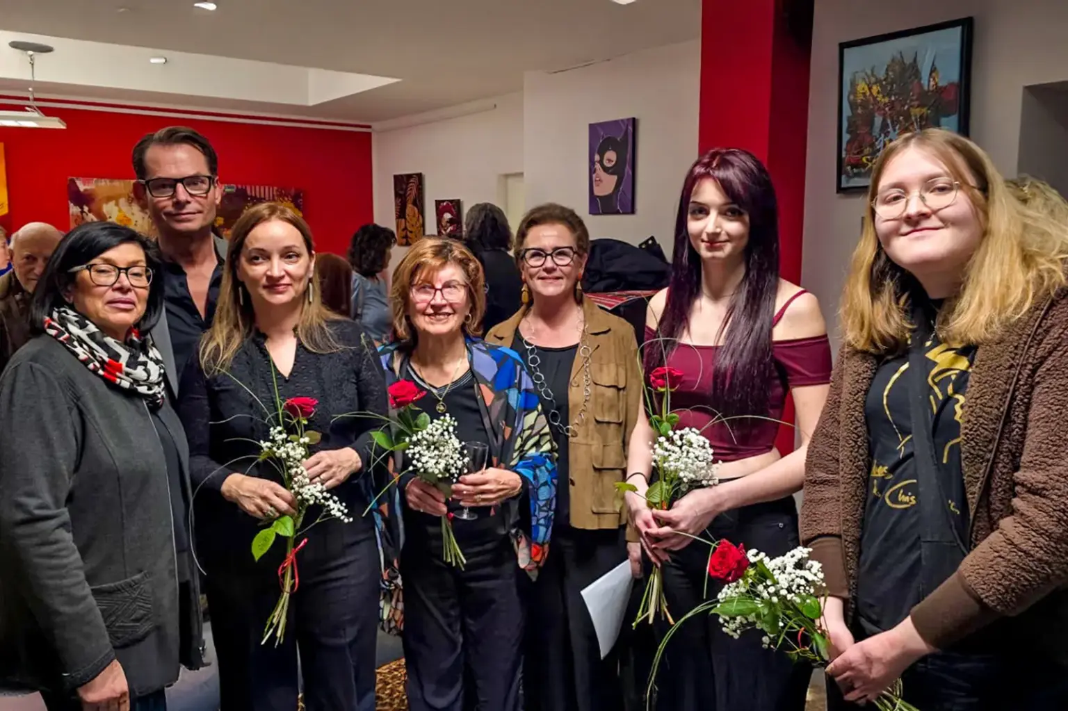 Sechs Frauen und ein Mann in einem Raum mit vielen Bildern
