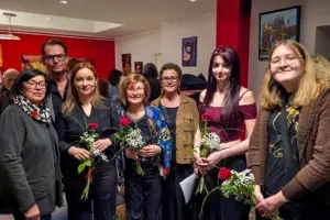 Sechs Frauen und ein Mann in einem Raum mit vielen Bildern