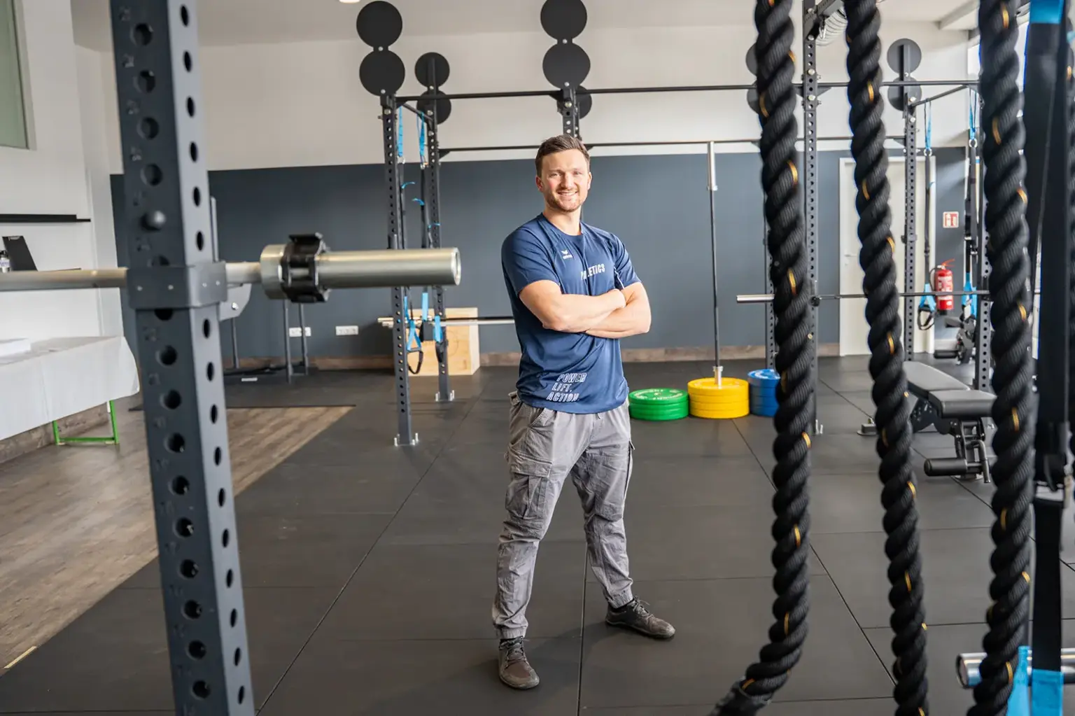 Ein Mann steht in einem Raum mit vielen Sportgeräten