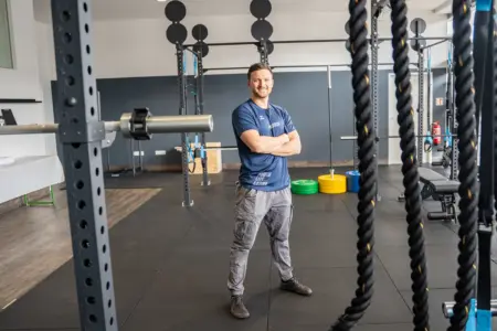 Ein Mann steht in einem Raum mit vielen Sportgeräten