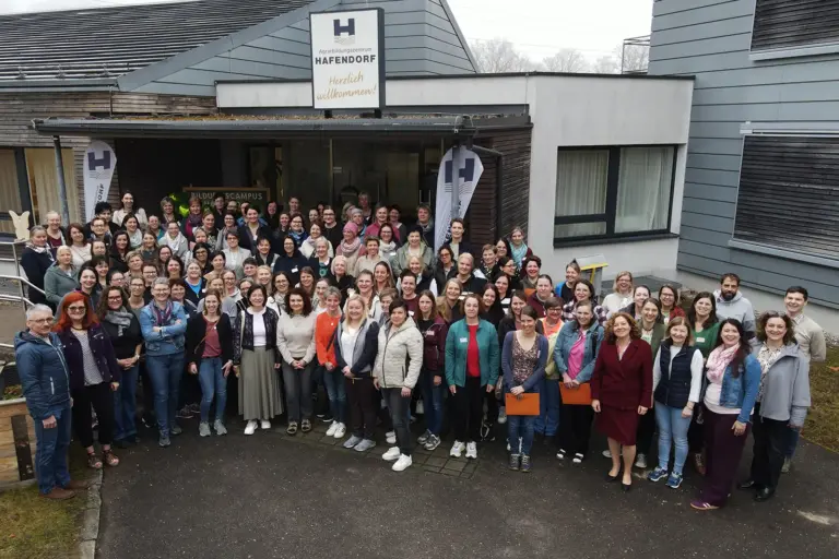 Eine große Gruppe von Personen vor einem Haus