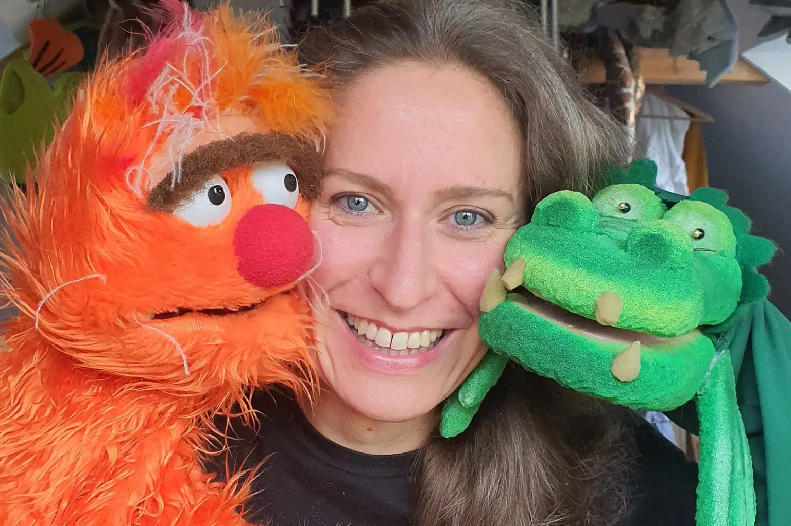 Eine Frau posiert mit zwei Puppen