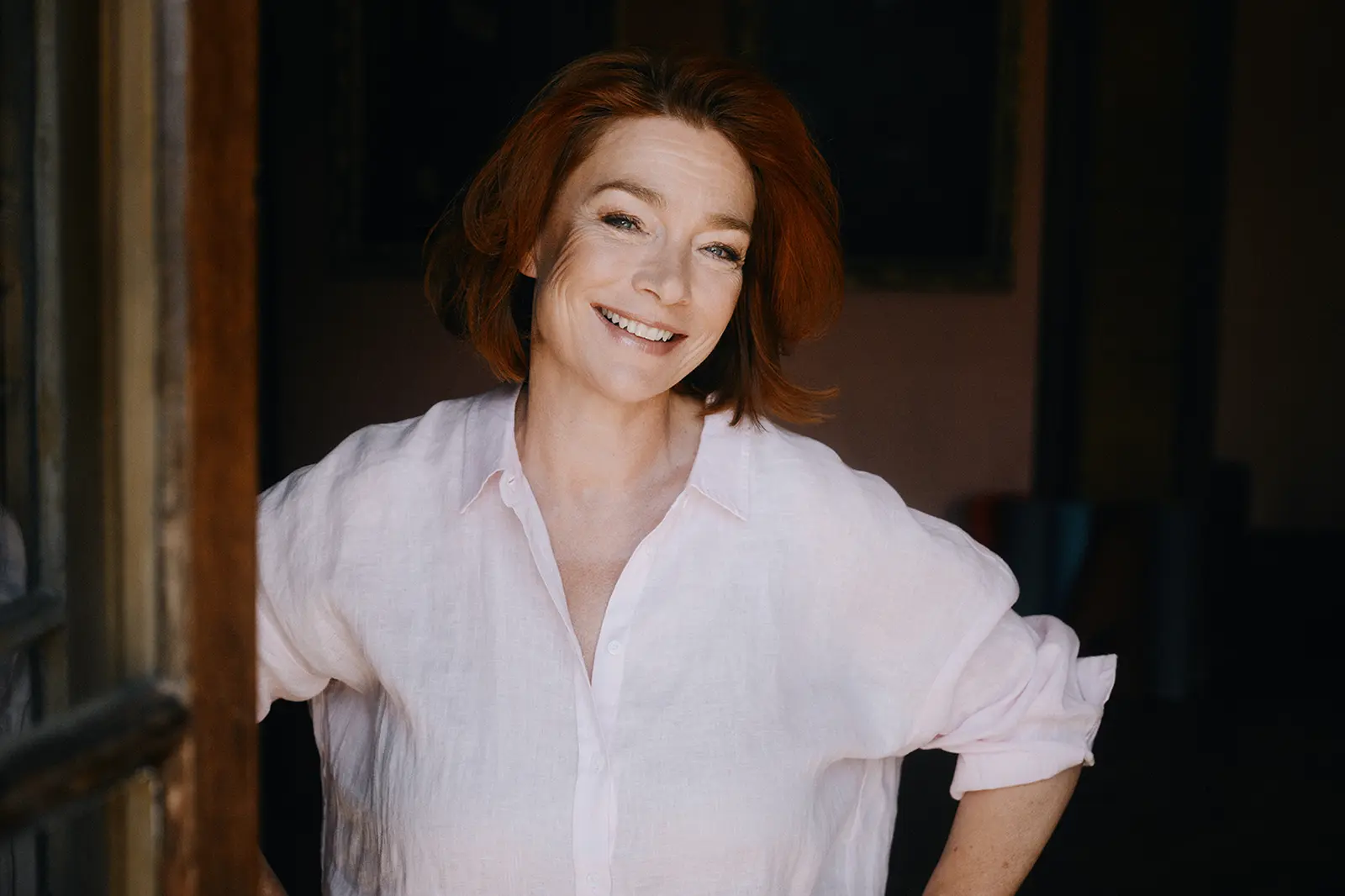 Eine Frau steht an einem offenen Fenster