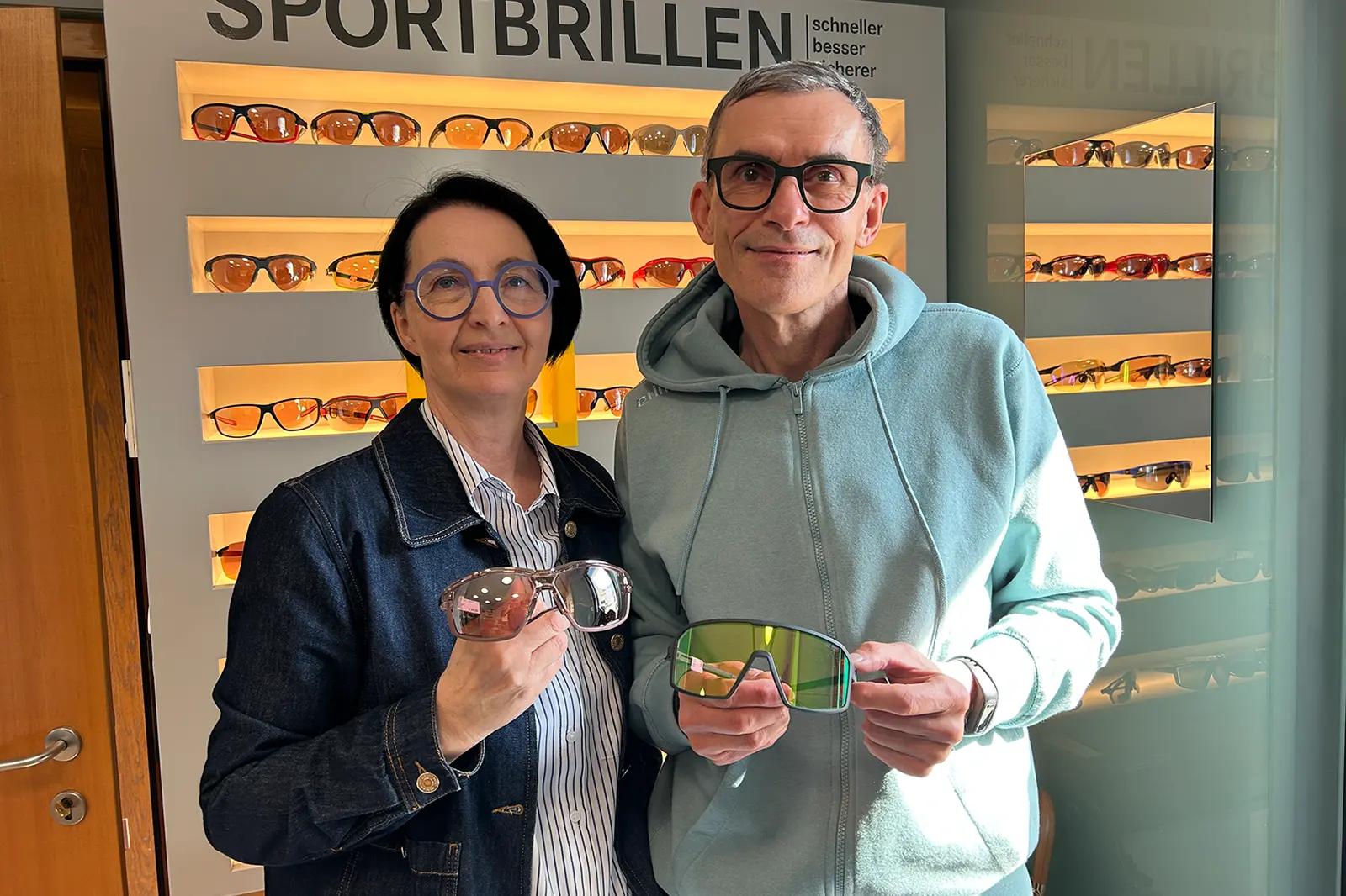 Ein Mann und eine Frau zeigen verschiedene Brillen