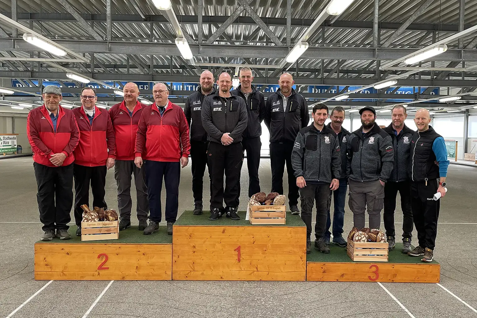 13 Männer auf einem Siegerpodest.