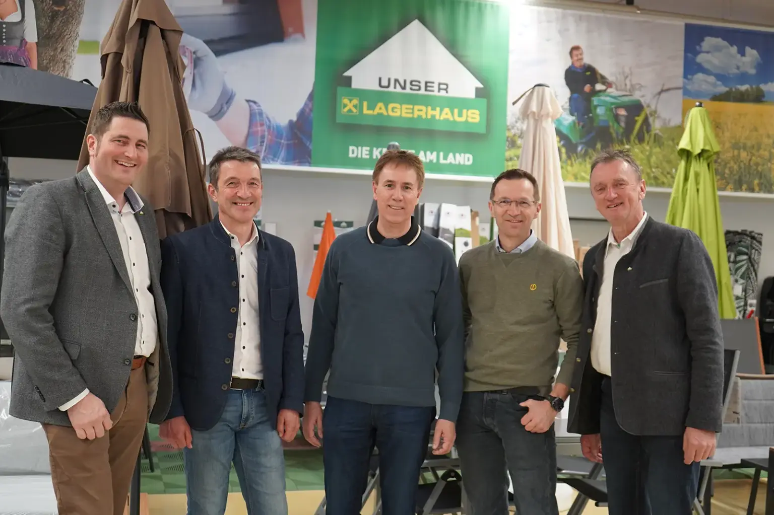 Fünf Männer stehen vor einer Gartenmöbelausstellung
