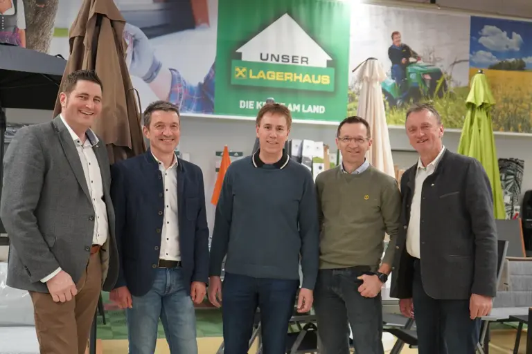 Fünf Männer stehen vor einer Gartenmöbelausstellung