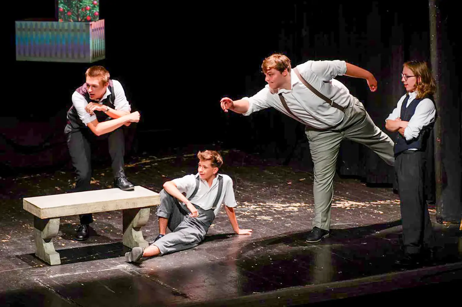 Vier junge Personen auf einer Theaterbühne