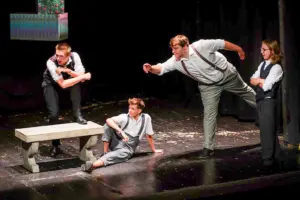 Vier junge Personen auf einer Theaterbühne