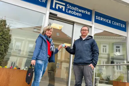 EIn Mann und eine Frau stehen vor einem Geschäftslokal