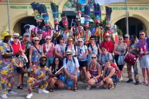 Eine Gruppe von Personen verschiedener Ethnien in teils bunten Gewändern vor einem Gebäude