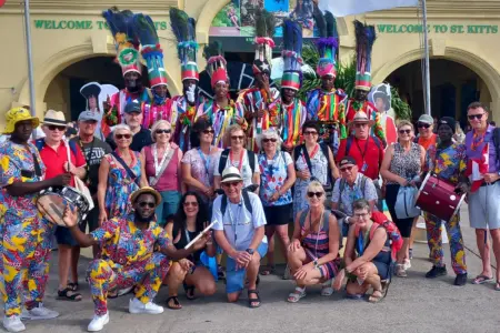 Obersteirer auf großer Reise Eine Gruppe von Personen verschiedener Ethnien in teils bunten Gewändern vor einem Gebäude