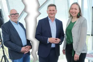 Zwei Männer und eine Frau in formaler Kleidung, der Bildabschnitt mit einem der Männer ist abgerissen