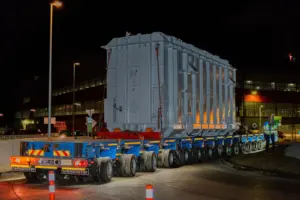 Ein großes kastenförmiges Gerät auf einer Ladefläche mit vielen Rädern