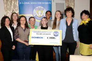 Neun Frauen mit einem Spendenscheck