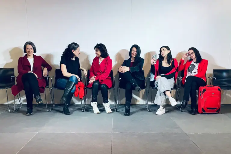 Theater zur Frauenrolle in der Region Sechs Frauen sitzen auf Sesseln an einer Wand