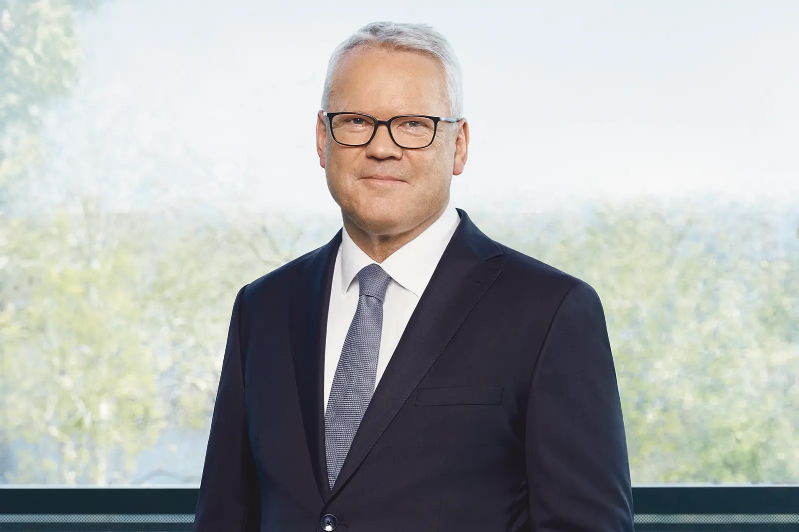 Ein älterer Mann mit Brille und Anzug