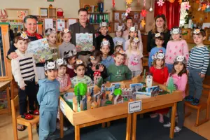 Ein Mann und drei Frauen mit einer großen Gruppe Kindern mit lustigen Hüten