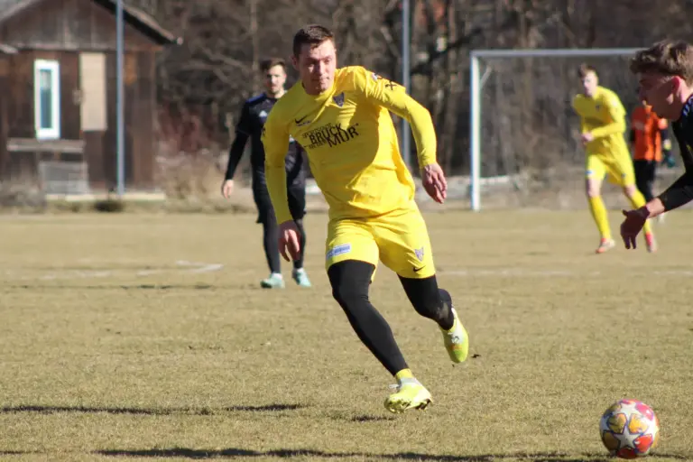 Ein Fußballer läuft einem Ball nach.