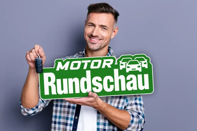 Der Autofrühling 2026 Ein junger Mann hält einen Autoschlüssel und eine Tafel mit dem Schriftzug "Motor Rundschau" in den Händen