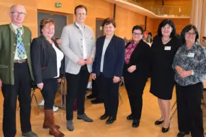 Sieben Personen in einem großen Raum